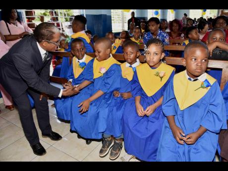 Credit: JIS Dr Norman Dunn (left), minister of state in the Ministry of Labour and Social Security, interacts with a graduate of the Early Stimulation Programme during the graduation exercise held on July 9, 2025, at the Apostolic Church of Jamaica, Bethel Temple, in