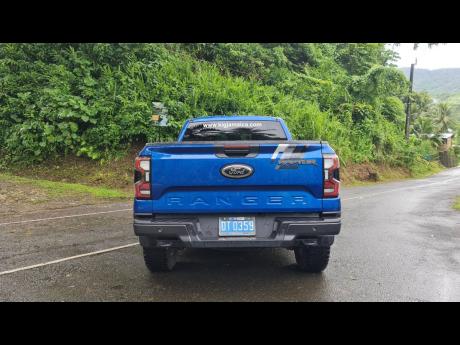 A rear perspective of the Raptor, showcasing its robust design and functional retractable load bed cover.