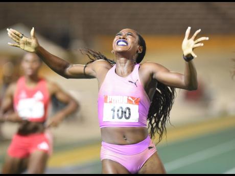 Rushell Clayton raises her arms in celebration of winning the 400-metre hurdles at the recent JAAA National Junior and Senior Championships at the National Stadium.
