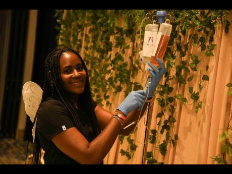 Credit: Antoine Lodge Registered nurse Shantae Wilson, CEO and founder of The Fairy Loft Med Spa, prepares the ‘Fairy Booster’ IV cocktail for a festival attendee at the Book Fairy Festival held earlier this month.