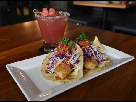 Fish tacos are new to One Park’s summer menu. The battered basa fillets, with freshly stewed cabbage, pickled ginger and a ginger pico de gallo salsa, are paired here with a watermelon margarita from the bar.