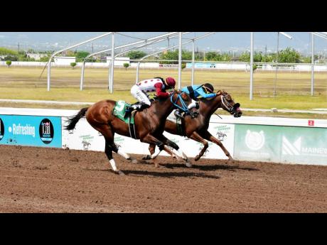 Anthony Minott/Photographer 
FUNCAANDUN (right), ridden by Robert Halledeen, winning the She’s A Maneater Trophy ahead of DESERT OF MALIBU (Raddesh Roman) over a mile at Caymanas Park yesterday.