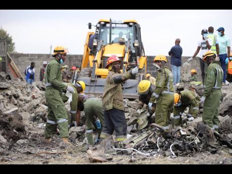Credit: Patrick Ngugi Firefighters search near the debris at the site of an airplane belonging to the African Medical and Research Foundation (AMREF) that crashed into a residential building in the Mwihoko area of Ruiru, in Kiambu County, Kenya, Wednesday, August 7, 2024. (AP P