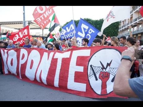 People hold a banner during a demonstration against the bridge in Messina, Italy. 