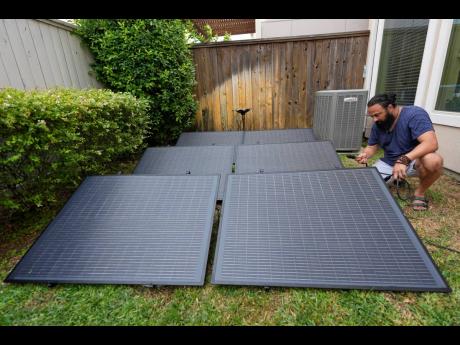 Credit: AP Bhavin Misra assembles a Craftstrom Solar plug-in kit at his home in Houston.