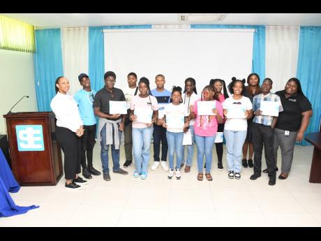 Credit: Contributed Participants in the JN Foundation field trip take a group photo at the Jamaica Stock Exchange. Also part of the photo are Sydoney Preddie (left), lead for youth and education programmes at the JN Foundation, and Chevanese Peters (right), project coordinato