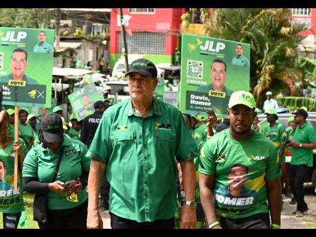 Credit: Ashley Anguin/Photographer Homer Davis, the Jamaica Labour Party’s candidate for St James Southern, leads his supporters on the way to the nomination centre.