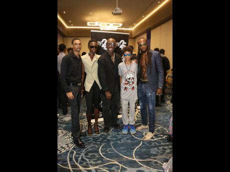 Credit: Nathaniel Stewart SAINT Chief Executive Officer Deiwght Peters (centre) poses for a backstage group photo with SAINT’s 2002 Male Fashion Face winner Marlando Vassell (right) and his 13-year-old son Teshai (second right), who both flew in from London, former Ferragamo glob