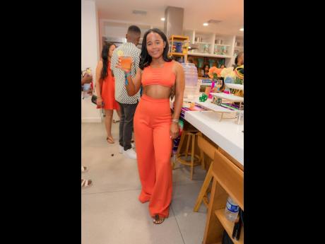 Shanice Mitchell, brand activator for Campari, shows off her chic style in a bold orange crop top and pants set.