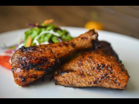 The honey jerk chicken at the Grace Jerk Hut is served with fries or coconut festivals.