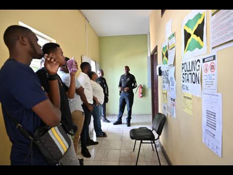 Members of the security force voting at the Jamaica Constabulary Force’s Harman Barracks on Camp Road in Kingston yesterday. 