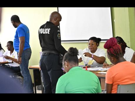 Members of the security force voting at the Jamaica Constabulary Force’s Harman Barracks on Camp Road in Kingston yesterday. 