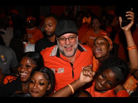 Opposition Leader Mark Golding interacts with People’s National Party supporters as he exits the party’s Old Hope Road, St Andrew headquarters after conceding the 2025 general election last night. 