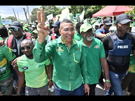 Dr Andrew Holness, (centre) and Kevin Hall, (second left) at the Waltham Park New Testament Church of God Nomination Centre on Nomination Day.