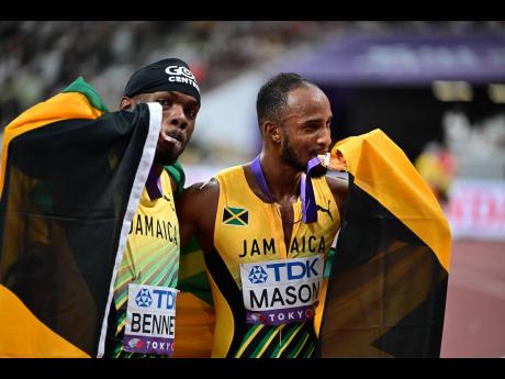 Tyler Mason (right) and Orlando Bennett celebrate the respective bronze and silver medals they earned from the men’s 110-metre final at the World Athletics Championships inside the Japan National Stadium yesterday in Tokyo. 