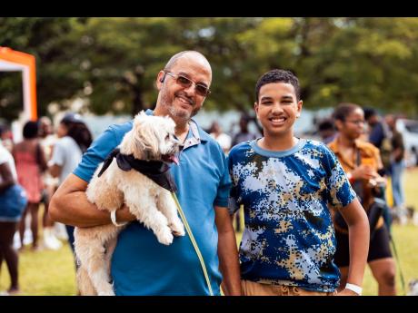 Andrew McCreath (left) from MacTours Ltd and his son Dominic pose with their dog, Charlie, at the last Yappy Hour held in March on the grounds of Immaculate Conception High. The next doggie social is scheduled for Sunday, September 28, at the Jamaica Horti