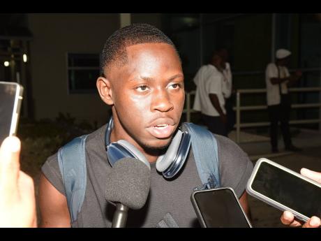 Oblique Seville talks with members of the media on his arrival at the Norman Manley International Airport from the Tokyo World Athletics Championships where he won gold in the men's 100 metres.
