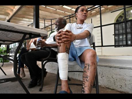 Sasha Bartley shows her injury leg which sustained a gaping wound after being struck by a piece of metal in the murky waters as she tried to rescue the couple.