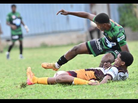 Calabar’s Kimani Thompson is felled by a cruching challenge from Wolmer’s Boys’ School’s D’Andre Campbell during their ISS/WATA Manning Cup Zone E playoff clash at the Mico University yesterday.