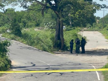 Investigators at the scene of a fatal police shooting along Grange Lane in St Catherine on October 9.
