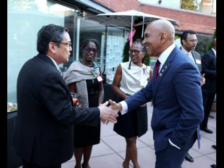 Jamaica’s ambassador to the United States, Major General (Ret’d) Antony Anderson, receives warm greetings from  Dr Raymond Tu at the reception hosted in his honour by the Foundation in Georgetown, Washington, D.C., on October 1. Looking on are Joy Rhod