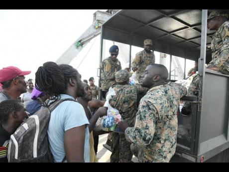 Credit: Antoine Lodge/Photographer Members of the Jamaica Defence Force hand out care packages to residents of Crane Road in St Elizabeth.