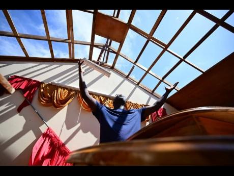 Credit: Gladstone Taylor/Multimedia Photo Editor Gladstone Taylor/Multimedia Photo Editor
Sherman Graham, pastor of Brucefield Gospel Chapel in Brucefield, St Elizabeth, in a moment of reverence at the pulpit of his roofless church on Thursday. The church is one of several across western Jamaica batter