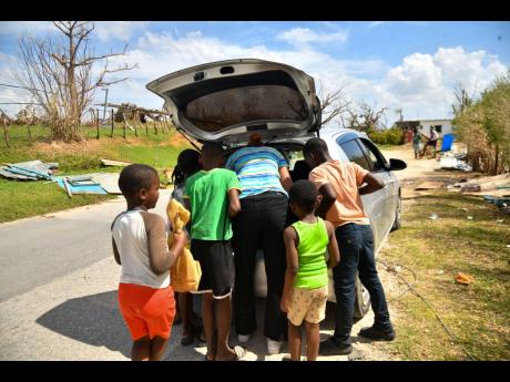 Children gather around to get porridge in Oxford, St Elizabeth.