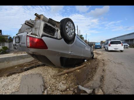 Credit: Ian Allen A car sits on its roof in Catherine Hall, a community in Montego Bay where homes, businesses and infrastructure suffered heavy damage due to Hurricane Melissa.
