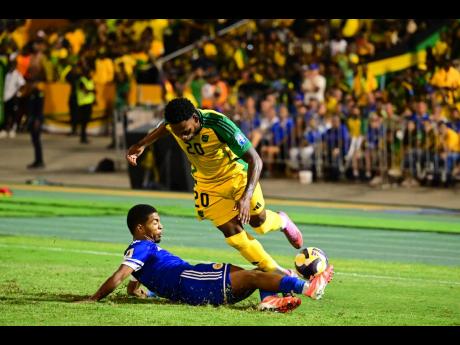 Curaçao’s Shurandy Sambo (left) tackles Reggae Boyz Renaldo Cephas.