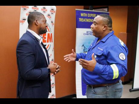 Credit: Contributed Commander Alvin Gayle, director general of the Office of Disaster Preparedness and Emergency Management (ODPEM) converses with Stephen Summers, country manager of Ansa Chemicals Jamaica, at the relief support handover at the ODPEM.