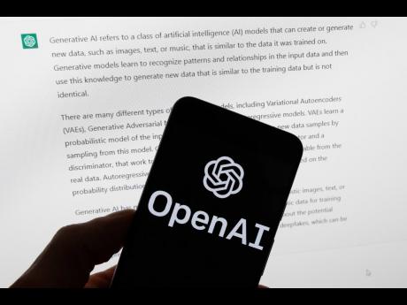 Credit: Michael Dwyer The OpenAI logo is displayed on a mobile phone in front of a computer screen with output from ChatGPT, March 21, 2023, in Boston. (AP Photo/Michael Dwyer, File)