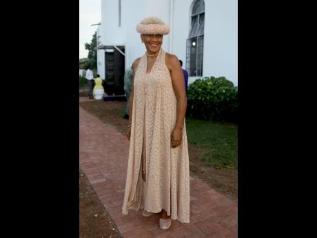 Dr Sherrill Chong delivers elegant style in a neutral maxi dress paired with a matching headscarf tied in a Heidi braid.