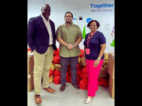 Corah Ann Robertson-Sylvester, president, SAJ, and Terrence Brooks, GM, SAJ, receive care packages from Carlos A. Murillo C., GM, ZIM–Carib Star (centre).