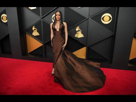 Credit: AP Styled by an all-woman glam squad, influencer Kristy Sarah steps out in a custom Nicole + Felicia dress.