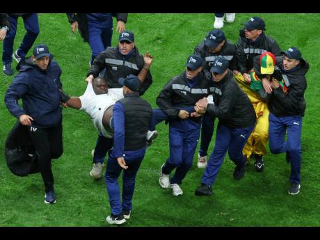 Senegal supporters are taken from the stadium by security officers after a controversial penalty was awarded to Morocco late on during the Africa Cup of Nations final footbal match in Rabat, Morocco on January 18.