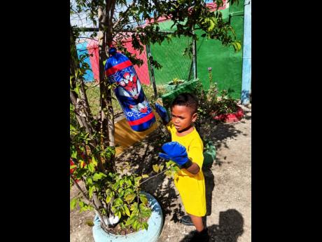 A young boy takes part in a fun boxing session during Play Day activities at Kingdom Builders Early Childhood Development Centre.

