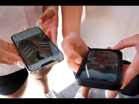 Young people use their phones to view social media in Sydney, November 8, 2024. 