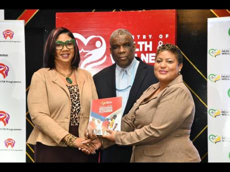 Minister of State in the Ministry of Health and Wellness, Krystal Lee (right), presents a copy of the National Strategic Plan for HIV 2023-2030, to Deputy Coordinator for the Caribbean Regional Programme, United States Embassy in Jamaica, Ava-Gay Timberlak