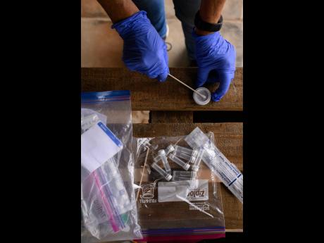 This image provided by Bat Conservation International shows citizen scientist Linda Moore using an eDNA collection kit to swab hummingbird feeders at a home in Silver City, N.M., Sept. 5, 2025. 