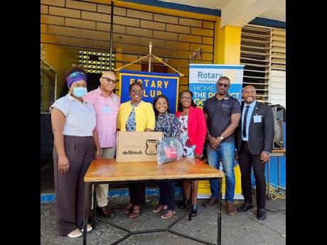 Rotary Club of New Kingston District Governor William Aiken (second from left) and president Alex Robinson (far right), joined by Vice‑Principal of Constant Spring Primary and Infant School Michelle Wiggins (fifth from left), during the handover of an AE