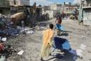 Youths use wheelbarrows to carry debris out of their homes, which were damaged by gang violence, in the Solino neighbourhood of Port-au-Prince, Haiti.