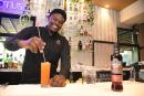 Mixologist Conroy Plummer happily prepares a tall glass of the pasi-flora.